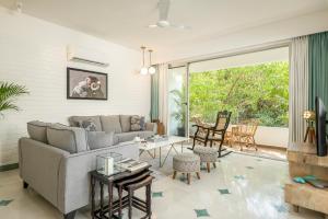 a living room with a couch and a table at El Tesoro by The Blue Kite - 2BHK Elegant Apartments in Siolim with Pool- 10 mins Drive to Assagao in Mapusa