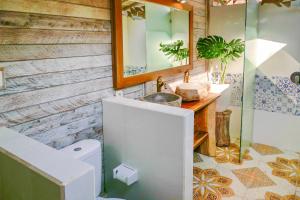 ein Badezimmer mit einem WC, einem Spiegel und einem Waschbecken in der Unterkunft Lembo Lagoon Bungalows in Nusa Lembongan