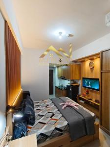 1 Schlafzimmer mit einem großen Bett und einer Küche in der Unterkunft Trans Park Juanda Bekasi By MJ Room in Padurenan
