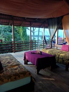 a room with two beds and a table with a cat on it at Old Bank Tea Garden in Bocas del Toro