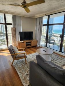a living room with a couch and a tv at Beachcomber Resort - Deluxe Rooms in Gold Coast