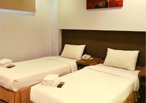 a hotel room with two beds with phones on them at Magallanes Square Hotel Inc. in Tagaytay