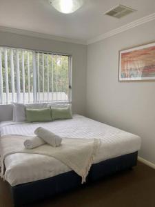 Un dormitorio con una cama grande con ventana. en Serene Wagga Townhouse Getaway, en Wagga Wagga