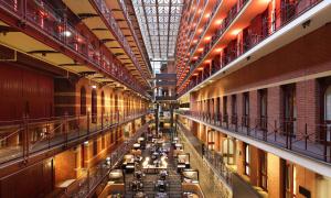 una grande stanza piena di tavoli in un edificio di InterContinental Melbourne The Rialto, an IHG Hotel a Melbourne