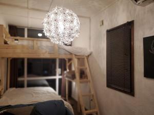 Cette chambre comprend un lustre et des lits superposés. dans l'établissement 真狩村焚き火キャンプ場, à Makkari