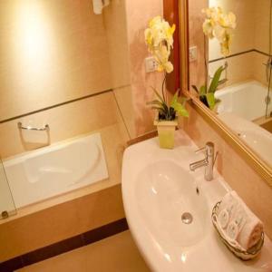 a bathroom with a sink and a mirror and a tub at Royal Garden Hotel in Ozamis +35 photos