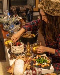 una mujer cortando un pastel en una mesa con comida en 真狩村焚き火キャンプ場 en Makkari