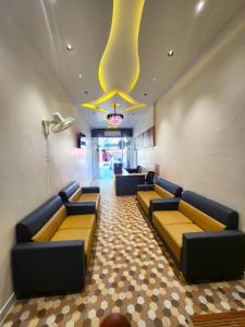 a waiting room with couches and a chandelier at Hotel Near Me in Rajkot