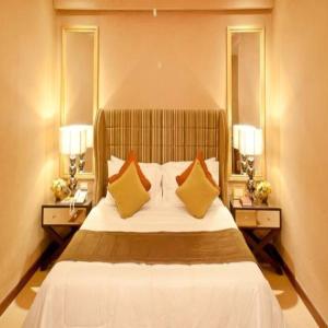 a bedroom with a bed with two lamps and mirrors at Royal Garden Hotel in Ozamis