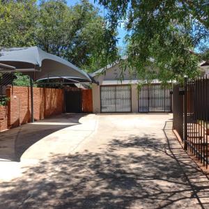a driveway with a gate and a fence at Cronin Luxury Accomodation Room 3 in Kimberley