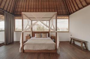 a bedroom with a canopy bed in a room at Villa Sunshine in Munggu