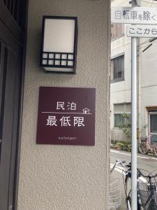 una señal en el lateral de un edificio con ventana en 福井駅から徒歩2分の1棟貸切民泊 最低限 en Fukui