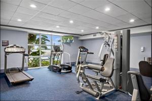 a gym with two treadmills and two tread machines at Balcony King Suite - Lake & Pool view in Orlando