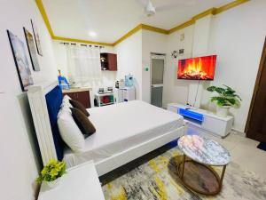 a bedroom with a white bed and a kitchen at Studio Apartment Bamburi0711519879 Near JSB BlockA in Mombasa