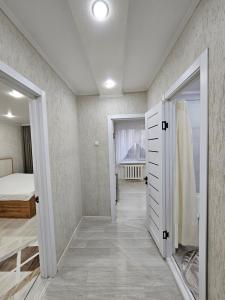 um quarto com uma cama, uma janela e uma porta em 1 ком квартира ТД Астана em Oral