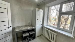 uma cozinha com um frigorífico e 2 janelas em 1 ком квартира ТД Астана em Oral