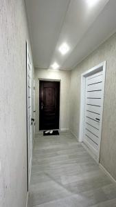 um corredor com uma porta e um quarto com piso em azulejo em 1 ком квартира ТД Астана em Oral