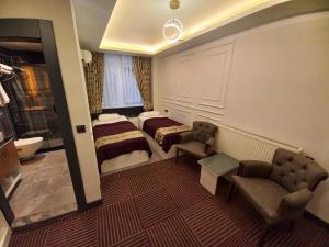 ein Hotelzimmer mit 2 Betten und einem Bad in der Unterkunft GRAND BELLİ OTEL in Altındağ