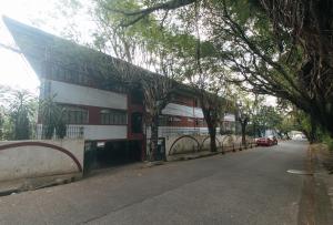 een gebouw aan de zijkant van een straat met bomen bij RedDoorz at Broadway Court Apartelle II Quezon City in Manilla