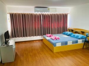 a bedroom with a bed and a television in a room at ImpactMuangthong C6,C7,C8,C9 in Nonthaburi