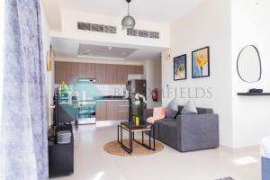 a living room with a couch and a kitchen at 308-magnificent Studio Raha View in Abu Dhabi