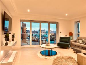 uma sala de estar com um sofá e uma mesa em 34 Cliff Edge 2nd floor Newquay luxury sea-view residence em Newquay