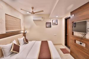 a bedroom with a bed and a flat screen tv at FabHotel Prime Candlewood by A plus Hospitality in Udaipur