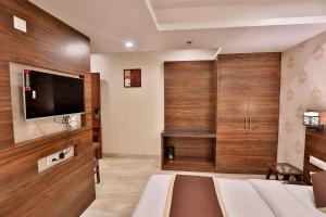 a bedroom with wood paneling and a flat screen tv at FabHotel Prime Candlewood by A plus Hospitality in Udaipur