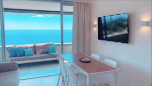 a living room with a table and a couch at COSTA PLANA - Unique Apartment for 8 PAX in Cap d'Ail