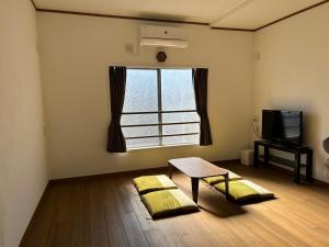 a living room with a table and a window at もりぞう in Tomioka