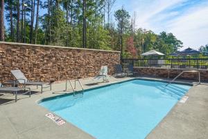 a swimming pool with chairs and a brick wall at Fairfield by Marriott Inn & Suites Hardeeville I-95 North in Hardeeville