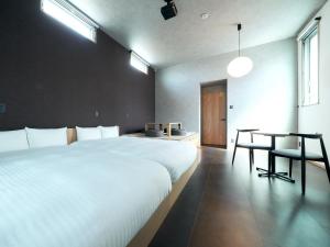 1 dormitorio con 2 camas blancas y mesa en Rakuten STAY Hakata Gion 101 Superior Room, en Fukuoka