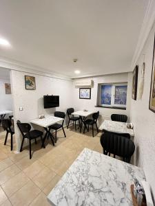 a restaurant with tables and chairs and a flat screen tv at Timex Suites in Istanbul