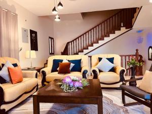 馬斯喀特的住宿－ONE Prestine Beach Villa，客厅设有两张沙发和一个楼梯