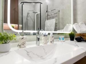 y baño con lavabo blanco y espejo. en ЖК "4You" one room apartment, en Almaty