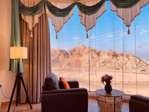 a living room with a large window with a mountain view at ONE Prestine Beach Villa in Muscat