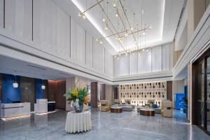 un vestíbulo de un hotel con sofás y mesas en Holiday Inn Express Bazhong Center, an IHG Hotel, en Bazhong