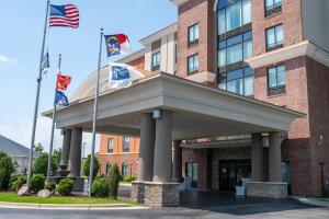 un edificio con tres banderas delante en Holiday Inn Express Hotel & Suites Hope Mills-Fayetteville Airport, an IHG Hotel, en Hope Mills