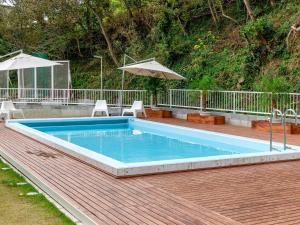 a pool on a deck with chairs and an umbrella at KR base Villa IzuShirahama Resort - Vacation STAY 33291v in Shimoda