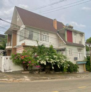 ein weißes Haus mit Blumen davor in der Unterkunft Lagi Sunrise Hotel in La Gi