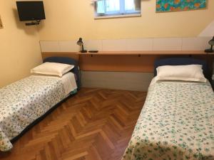 2 Betten in einem Zimmer mit einem TV in der Unterkunft Anthea Rooms in Split