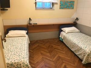 2 Betten in einem Zimmer mit Holzboden in der Unterkunft Anthea Rooms in Split