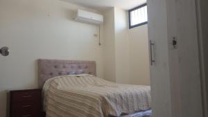 una piccola camera da letto con un letto e una finestra di Cozy Suite in cdla. Kennedy a Guayaquil