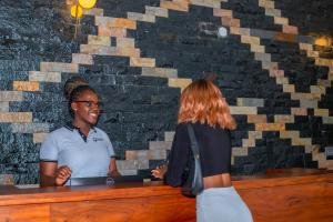 a man and a woman standing at a bar at Winmond Hotel in Wakiso