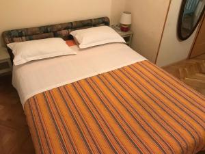 1 cama grande con manta de rayas naranja y blanca en Anthea Rooms, en Split