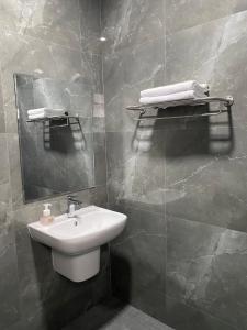 La salle de bains est pourvue d'un lavabo et d'un miroir. dans l'établissement Khampu Resident ก้ามปู เรสซิเด้นท์, à Maha Sarakham
