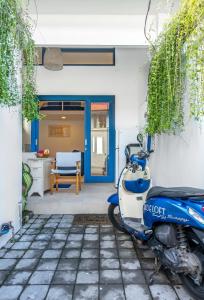 una moto azul estacionada frente a una casa en The Blue Loft Seminyak free scooter, en Seminyak