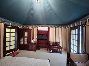 a bedroom with a bed and a blue ceiling at Royal Rajasthan Resort in Sīkar