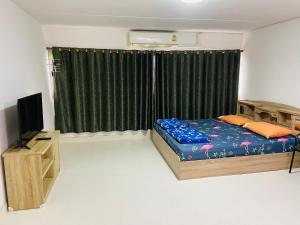 a bedroom with a bed and a television in it at Muangthong T4,T5near Impact,Challenger in Nonthaburi