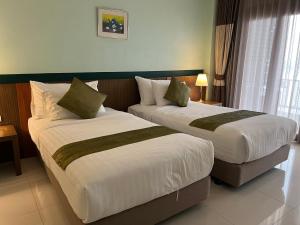 two beds sitting in a hotel room withskirts at Siam Triangle Hotel in Chiang Saen